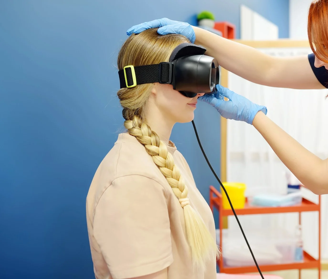Woman with vertigo symptoms is on appointment of neurologist. Doctor making positional testing of patient with using VNG for determine type of dizziness and performing Epley maneuver
